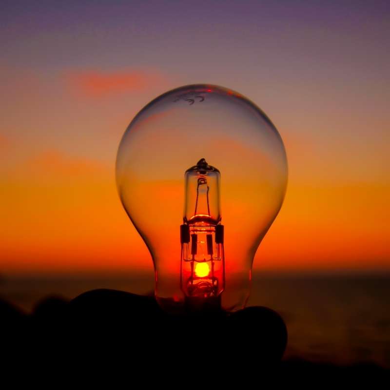 A light bulb with the sun shining through it.