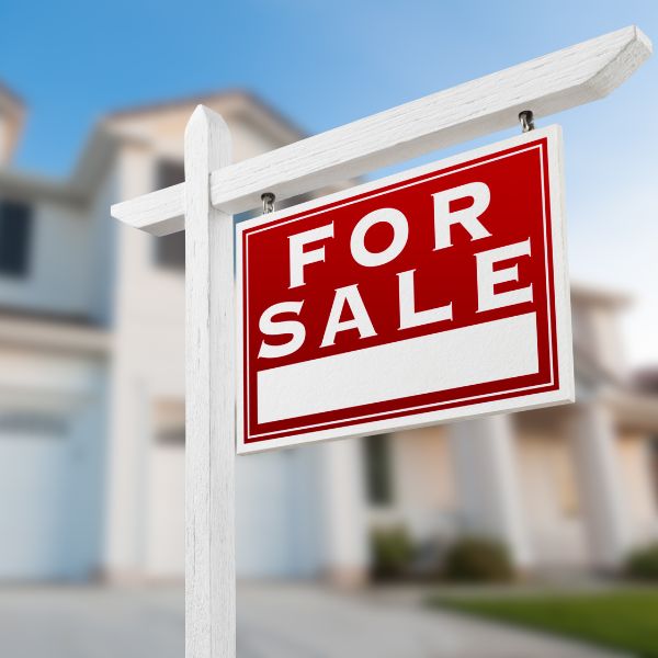 A for sale sign in front of a house.